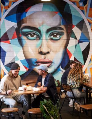 people dining near a vibrant wall art in Adelaide Central Market
