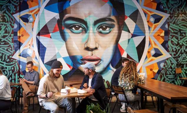 people dining near a vibrant wall art in Adelaide Central Market
