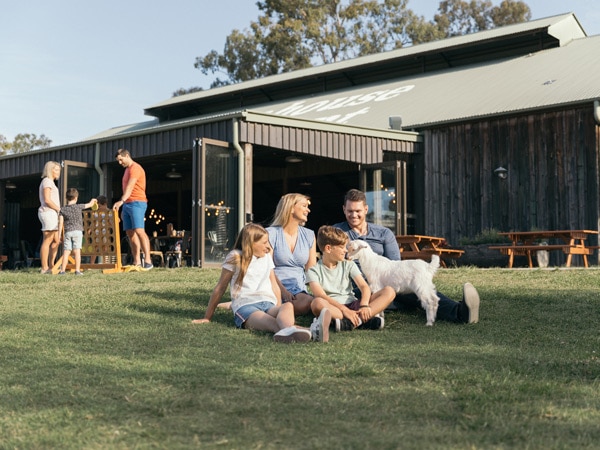 a family sitting on the grassy grounds of Paradise Country