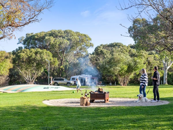 a family with their pet dog relaxing at Robe Holiday Park