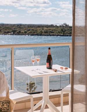 Wine on the balcony at the deluxe king room of Rydges Port Macquarie with water views.