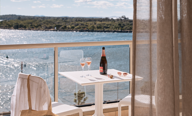 Wine on the balcony at the deluxe king room of Rydges Port Macquarie with water views.