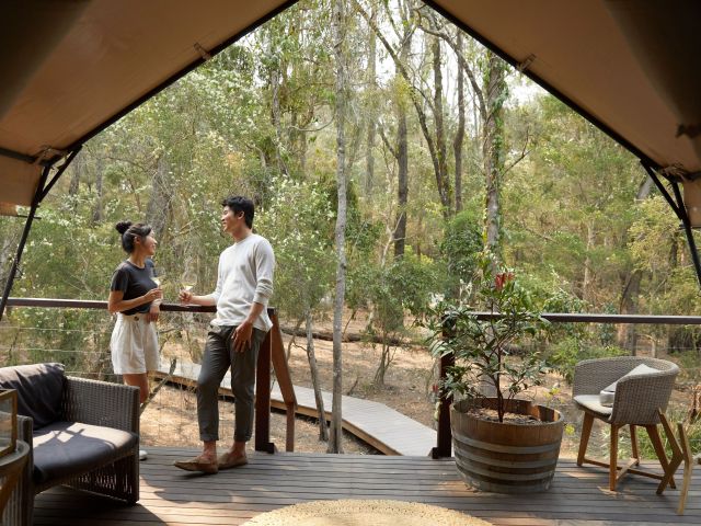 a couple enjoying a romantic glamping getaway at Paperbark Camp, Woollamia