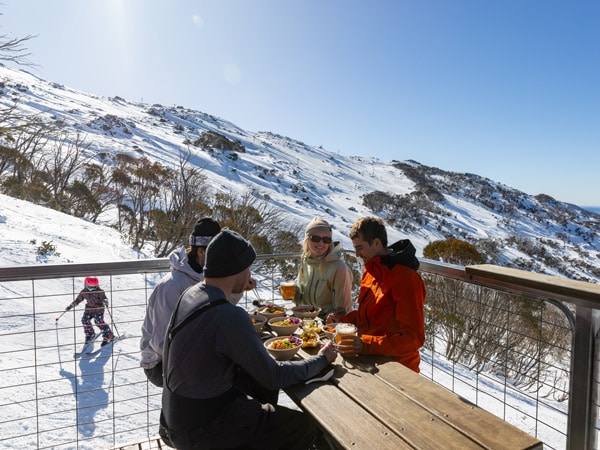 friends dining on the outdoor deck of Black Sallees, Thredbo