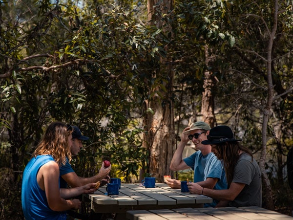 a group of people chilling under the trees at Harry’s Hut