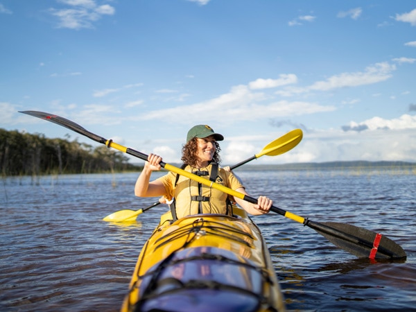 a woman paddling through the Noosa Everglades