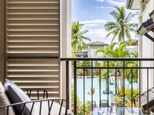 a suite balcony with views of the lagoon pool, Pullman Port Douglas Sea Temple Resort & Spa