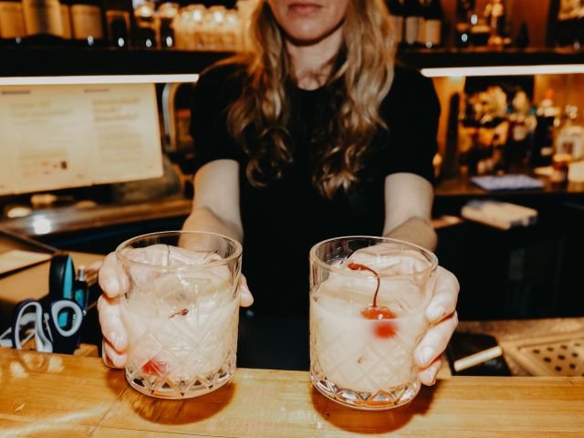 a bartender holding two glasses of cocktail at FarmDog Brewing, Geelong pub
