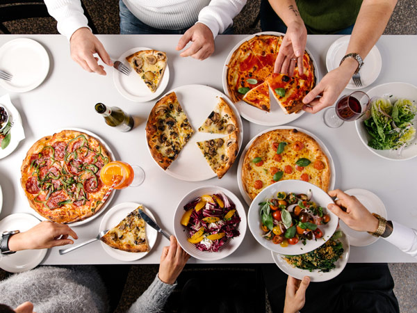 pizzas and pastas on the table at Pino's Trattoria, Phillip Island