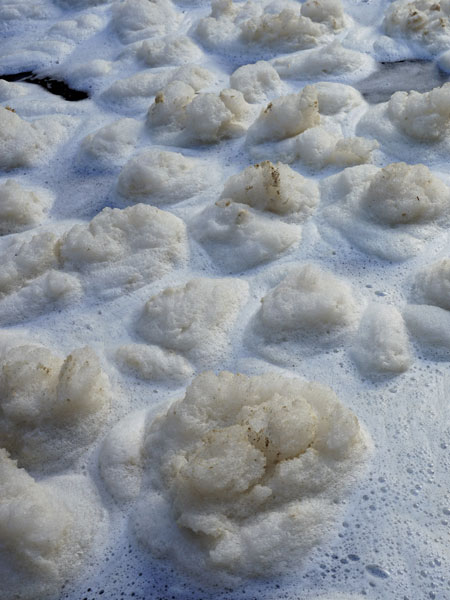 Fizzing foam forms on the surface of the river