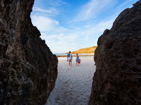 Couple walking through cave to get to Stokes Bay.