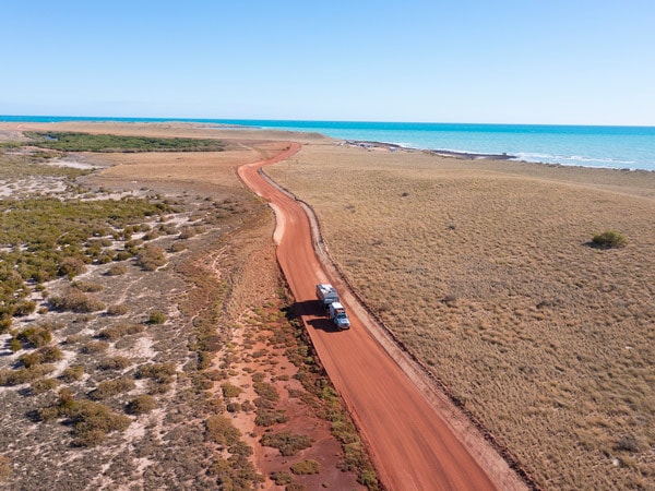 A car drives the red dirt roads in Cape Keraudren, east of Port Hedland in the Pilbara region of Western Australia. (Image: Tourism Western Australia)