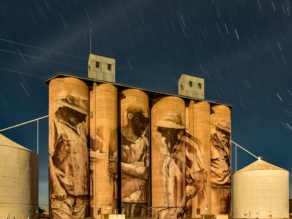Guido van Helten's silo art in Brim depicts a multi-generational quartet of female and male farmers across four silos. (Image: Visit Victoria/Anne Morely)