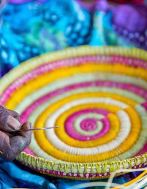 an Indigenous artist weaving a basket at the Injalak Arts and Crafts Centre