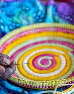 an Indigenous artist weaving a basket at the Injalak Arts and Crafts Centre