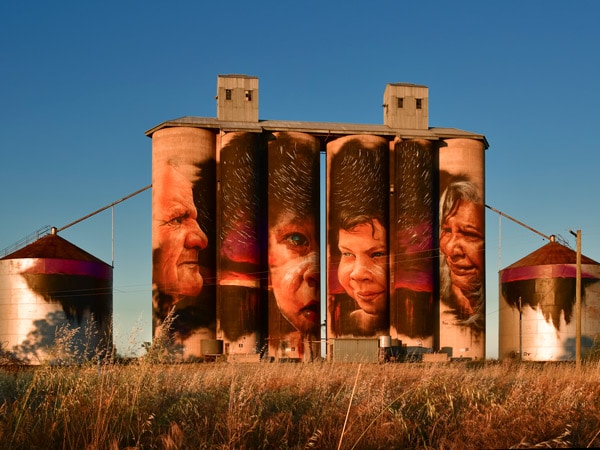 Silo Art at Sheep Hills by Adnate depicts Wergaia Elder, Uncle Ron Marks, Wotjobaluk Elder, Aunty Regina Hood, with children, Savannah Marks and Curtly McDonald. (Image: Visit Victoria/Anne Morely)