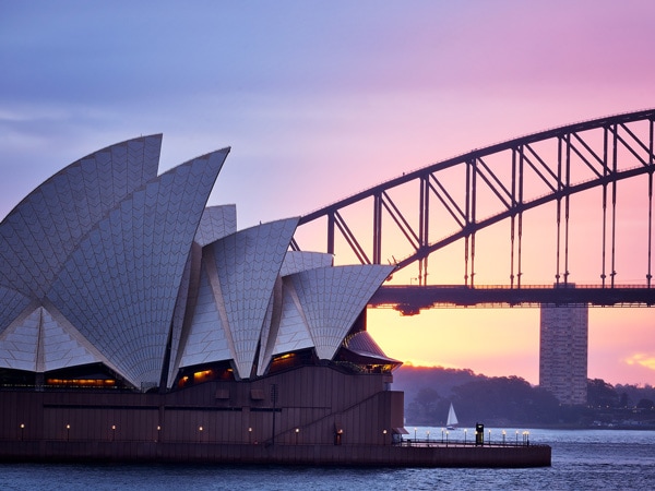 The Sydney Opera House and Sydney Harbour Bridge at sunrise. (Image: Destination NSW and Eugene Tan) 