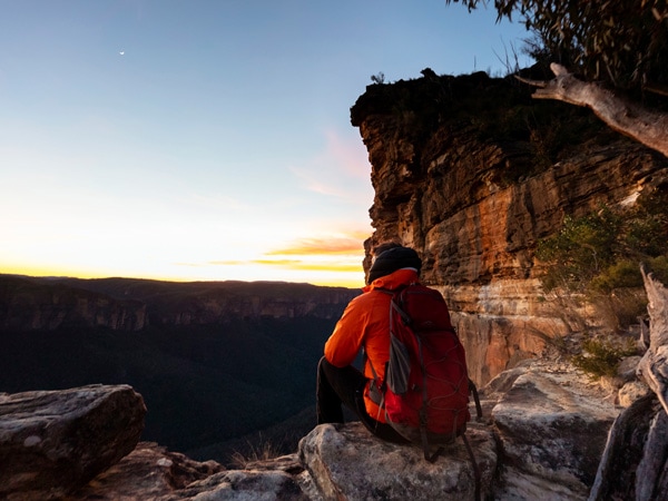 Man enjoying views of the sunset near Hanging Rock, Blackheath in the Blue Mountains National Park. (Image: Tyson Mayr)