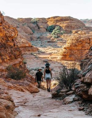 Man and woman trekking across Kings Canyon. (Image: Tourism NT and Jess Caldwell & Luke Riddle)