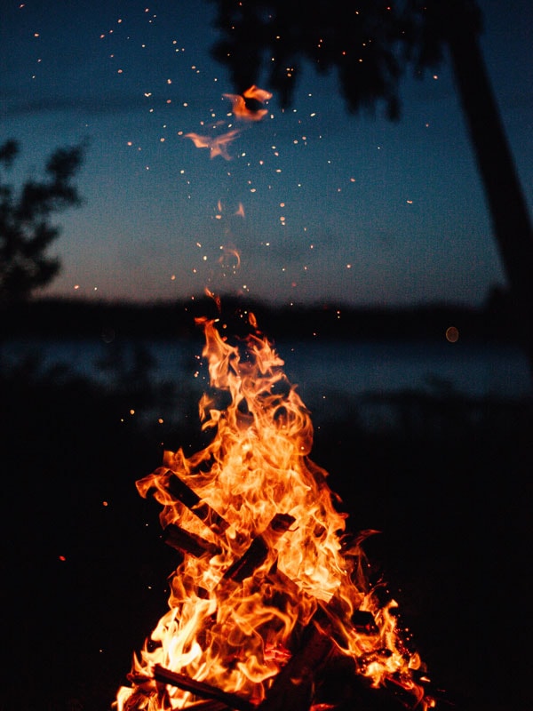 Campfire by lake at dusk