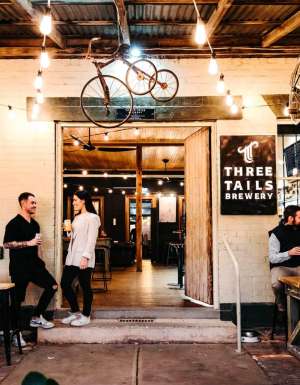 Patrons enjoying a drink at Three Tails Brewery