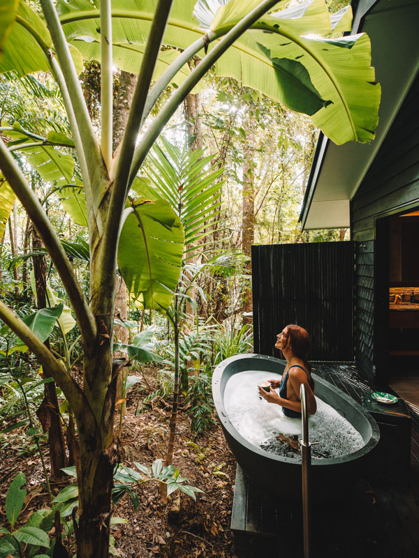 a woman bathing in an outdoor tub at Silky Oaks Lodge