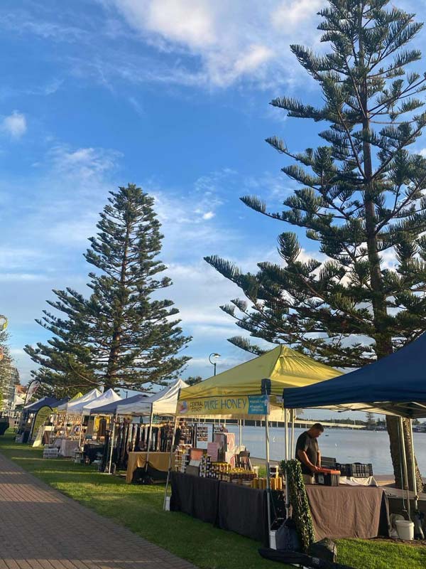 Stalls set up along the waterfront at The Entrance Markets on the Central Coast