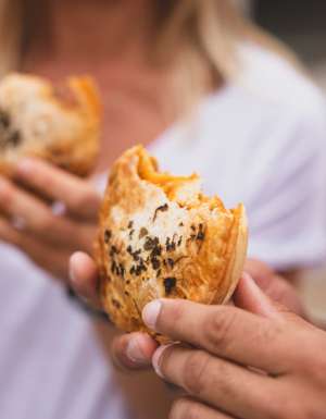 Couple enjoying pies from The Upper Crust pie shop, Collaroy (Image: Destination NSW)