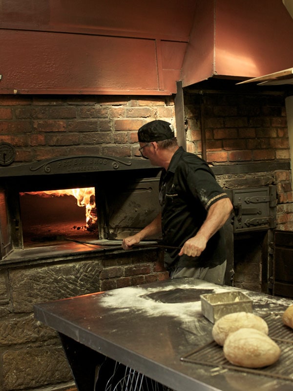 Baking in the wood fired oven at Ross Village Bakery. (Image: Tourism Tasmania and Adrian Cook)