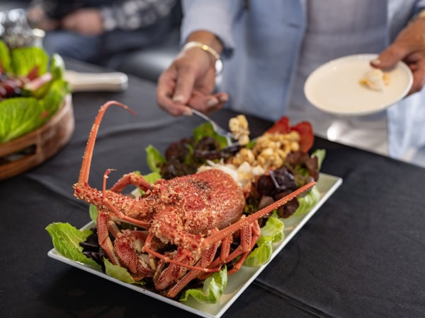preparing a rock lobster aboard Tasmanian Wild Seafood Adventures cruise