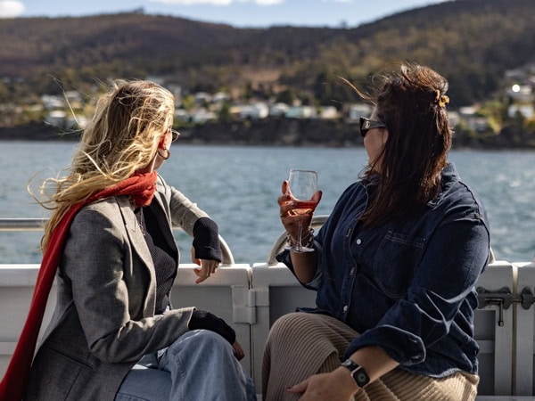 two women enjoying wine on a cruise with Tasmanian Wild Seafood Adventures