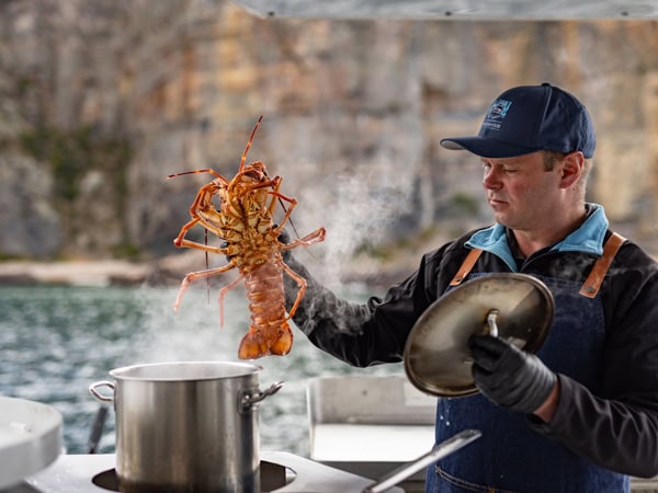 cooking a rock lobster at sea during the Tasmanian Wild Seafood Adventures