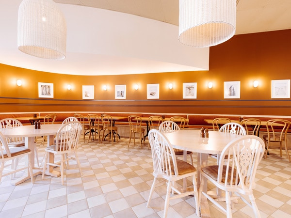 a vibrant dining interior with white chairs and tables at The Patch Tomakin
