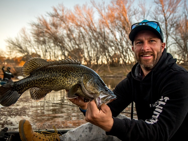 A man holding up a fish he caught fishing