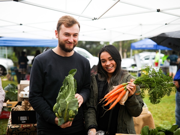 Two people purchasing produce at the Mountain Grower's Market Harvest Festival in Central Coast, Australia