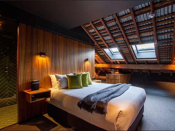 A cosy hotel room with a slanted roof. 