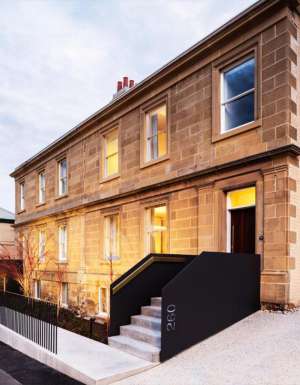 The house is made of stone and has a black railing.