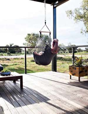 Woman sitting in a swing hammock in Callubri Station, NSW, Australi