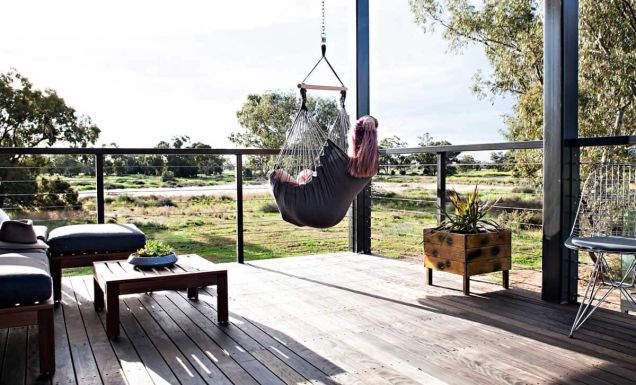 Woman sitting in a swing hammock in Callubri Station, NSW, Australi