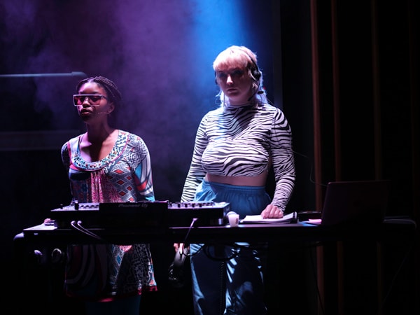 Two girls standing in a dark room and performing