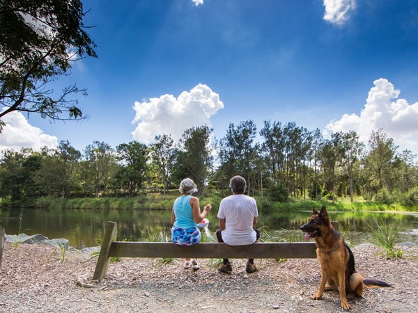 a couple sitting next to a dog at Bunya River