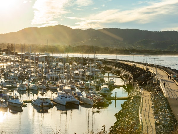 Boats docked in a marina between mountains.