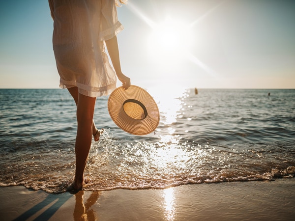 woman travelling alone in Australia and walking alone on sandy beach