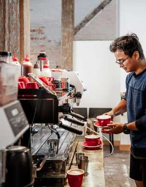 Barista making coffee at Bread + Butter Launceston