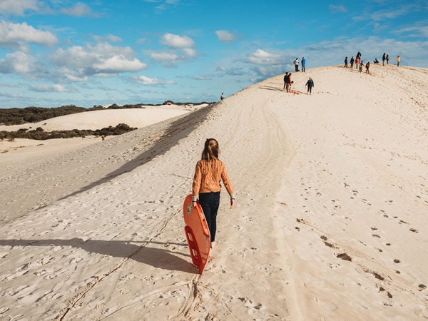 Girl carrying bodyboard at Little Sahara adventure centre