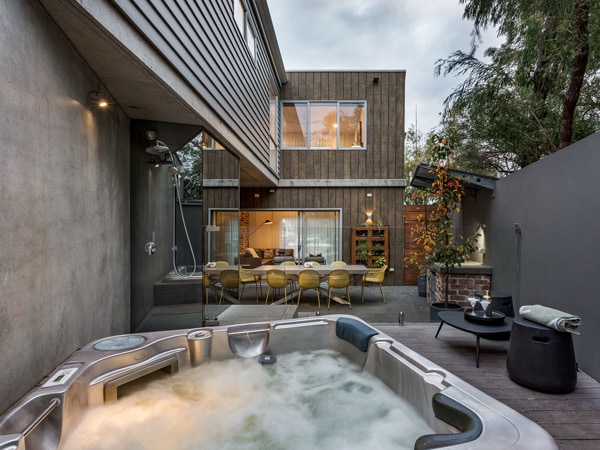 A jacuzzi on a deck with a table and chairs.