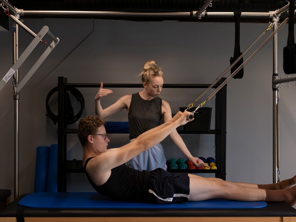 A girl training a boy on a mat.
