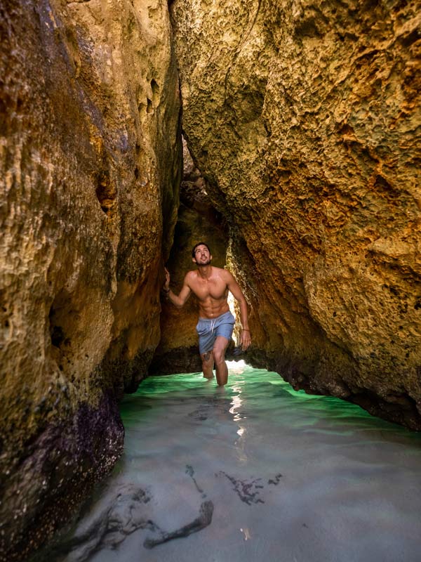 Man wades through the cave to get to Stokes Bay. 