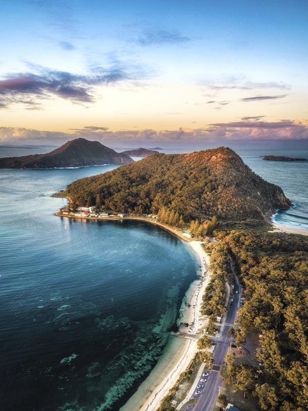 A mountain with the ocean and roads.