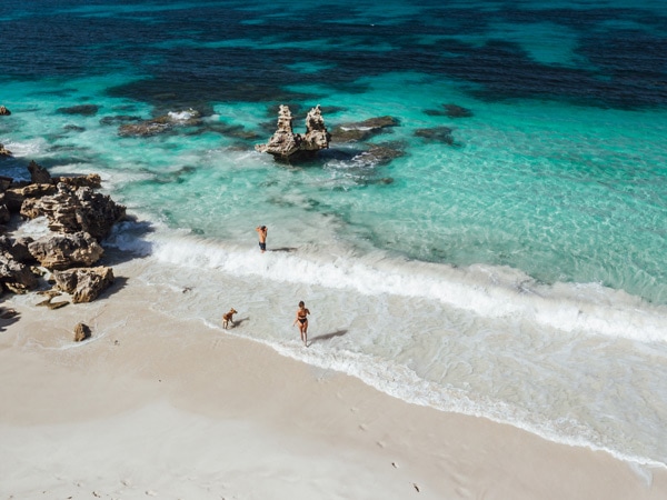 People and dog walking into ocean at Vivonne Bay. 
